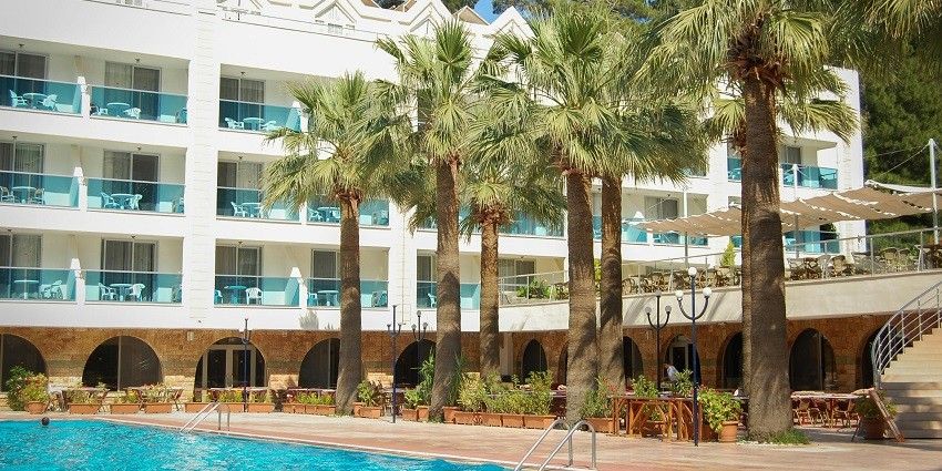 panoramic snap of a whitle marbled hotels with the lush palm trees and pool