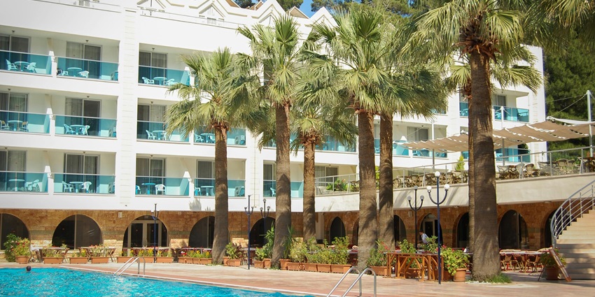 Beautiful image of a pristine hotel with pool and palm trees in the vicinity of the city