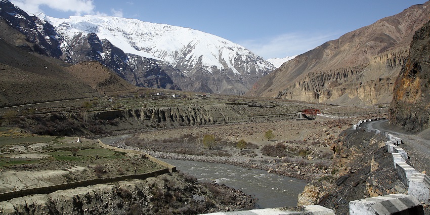 View of a road with a bridge in the Spiti Valley, surrounded by rocky mountains.