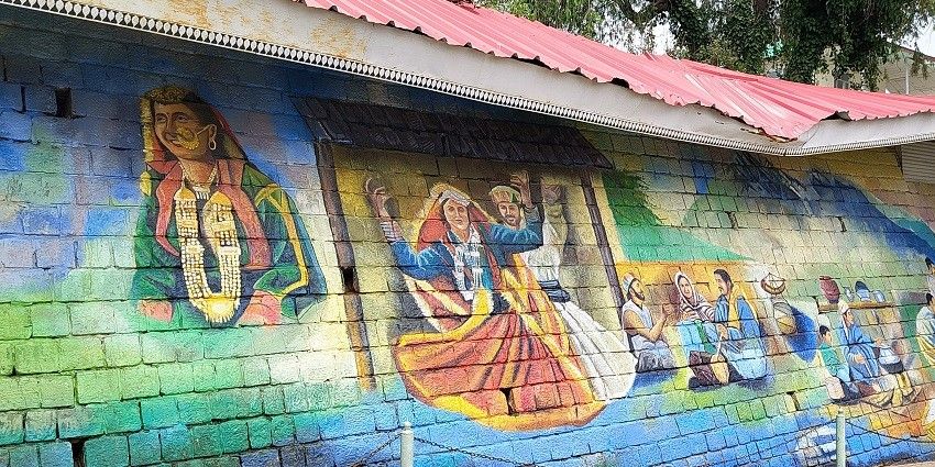 A picture of the exterior walls of Kangra Art Museum with wall art