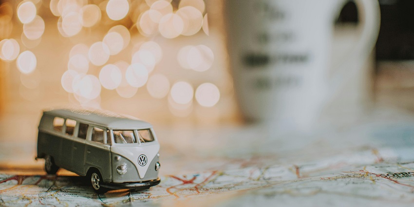 A mesmerising focused view of a miniature grey and white van standing on a paper map.