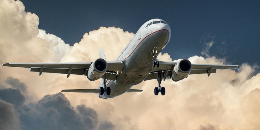 A stunning view of an aeroplane in the sky with dense clouds during the daytime.