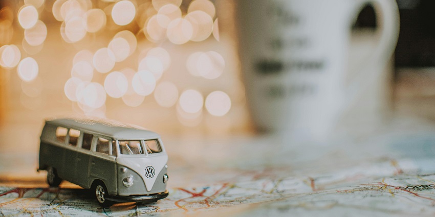 A fascinating view of a miniature green and grey bus on a colourful map on a table.