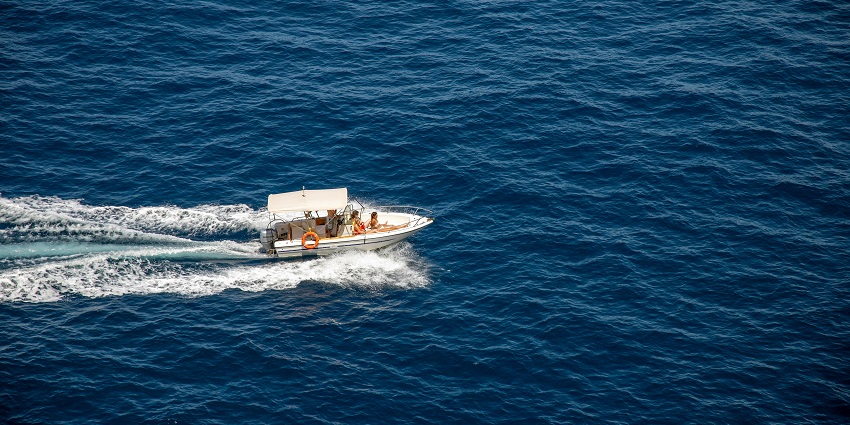 A breathtaking aerial view of a speed boat on turquoise waters of an ocean during the day.