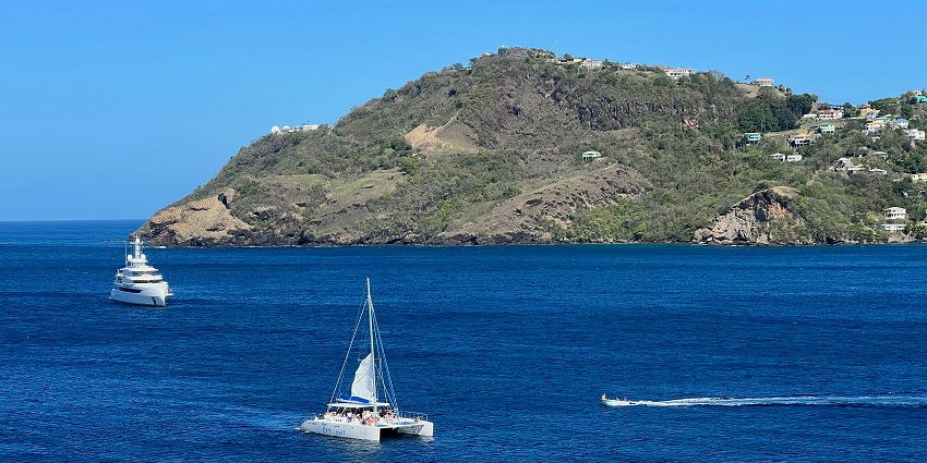 A stunning view of two ferries on a turquoise water body surrounded by lush greenery.