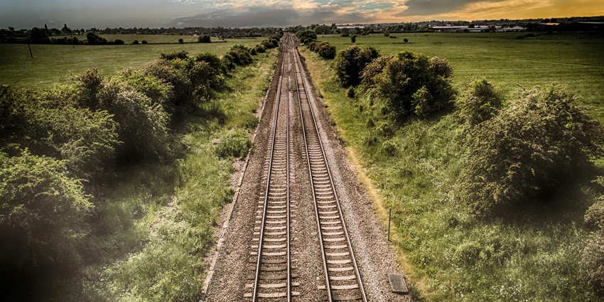 A breathtaking aerial view of a railway track passing through a lush green valley.