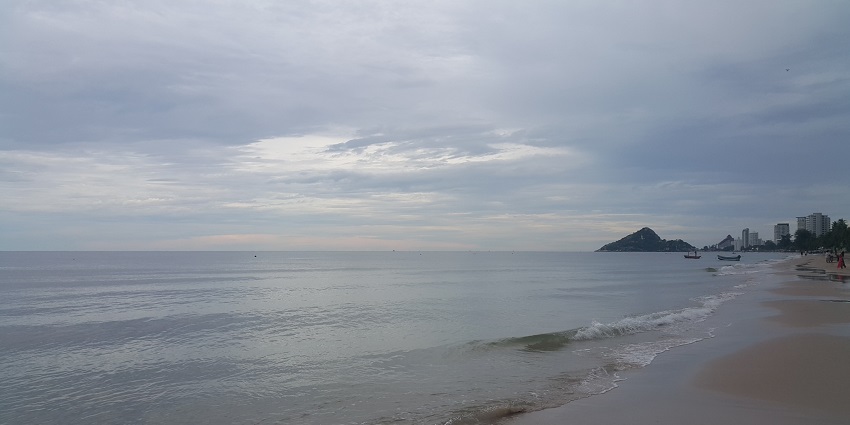 A picturesque view of shimmering waters hitting the sand at the Hua Hin Beach, Thailand.