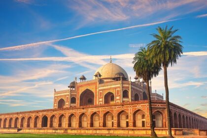 A picture of a famous tomb in Delhi with a big garden area in the front separated by a walkway