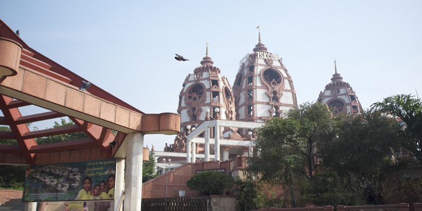 Image of the beautiful ISKCON temple amidst the lush green garden surrounded by trees