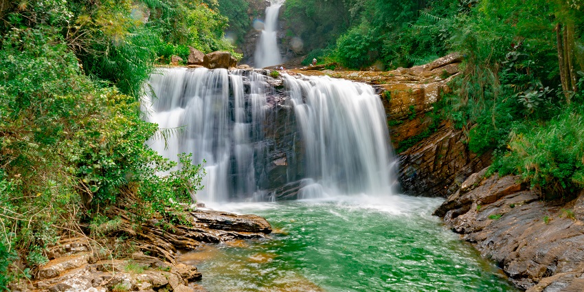 Picture of a serene and beautiful waterfall cascading through the rocks in a forest.