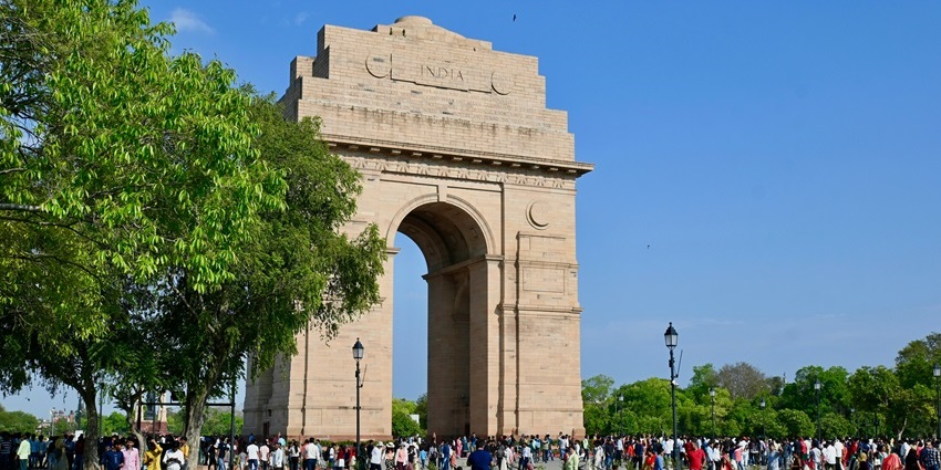 Image of India Gate during summer time visitors strolling around and enjoying picnic with families