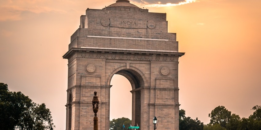 A grand war memorial illuminated at night, honoring Indian soldiers, one of the best places to visit near Red Fort.