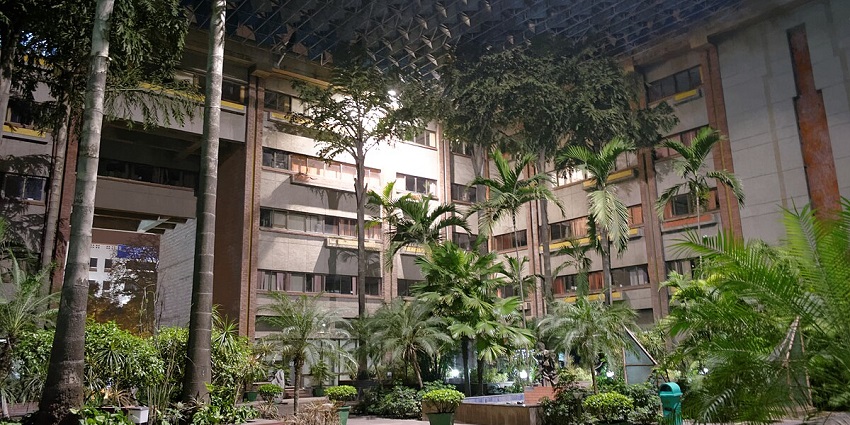 A building near Bangla Sahib surrounded by plants and greenery during nighttime