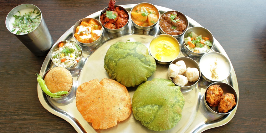 Mouthwatering south India thali with varieties of food to pick from the plate.
