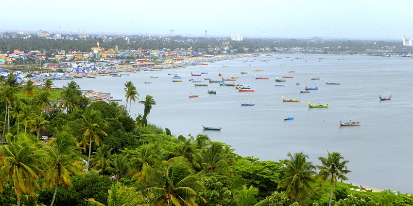 An aerial view of the Thangassery Beach featuring azure waters decked with boats.