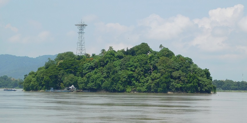 Umananda Island with its serene temple, lush greenery, and tranquil river setting.
