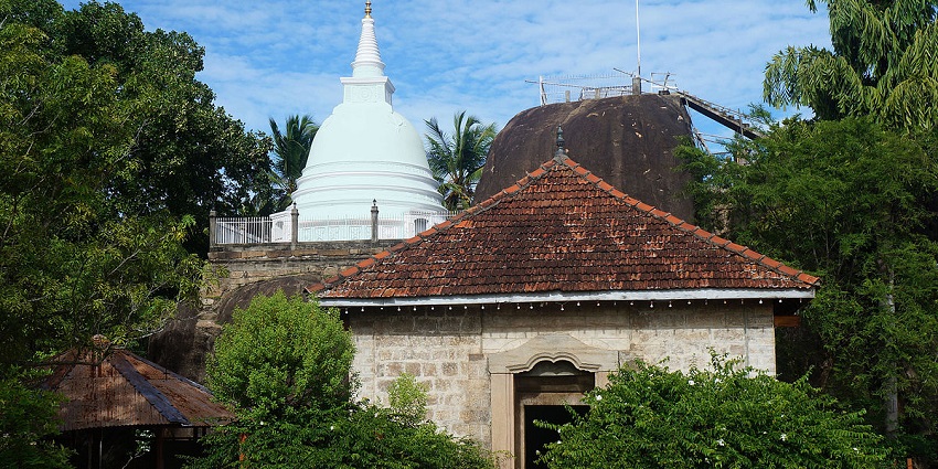 Scenic view of Isurumuniya Rock Temple, showcasing ancient carvings and lush surroundings.