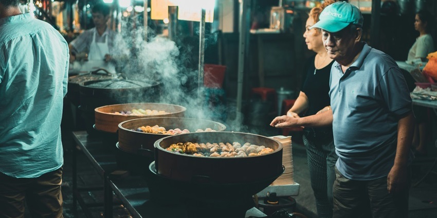 Image of shopkeepers selling traditional food in Malaysia at night street market - explore Jalan Alor Food Street