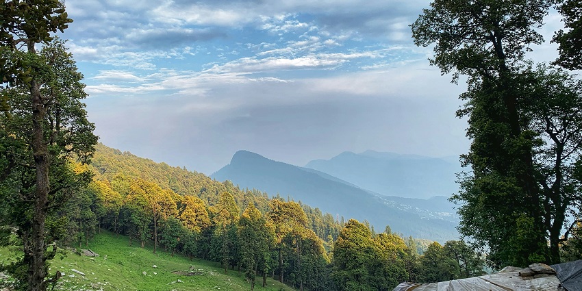 An astonishing view of towering peaks, misty clouds, and lush greenery at Jalori Pass.