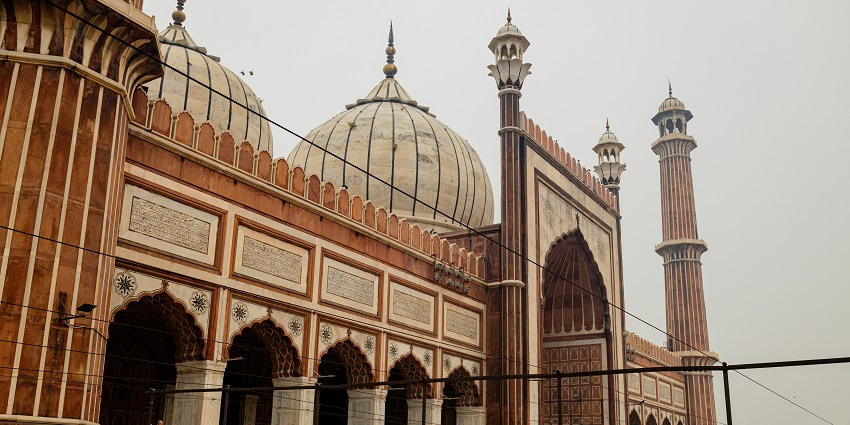 A breathtaking view of Jama Masjid with red and white architecture during the daytime.
