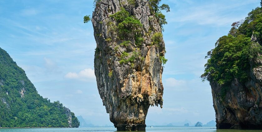 A scenic view of majestic peaks nestled amidst the azure waters of an island in Thailand.