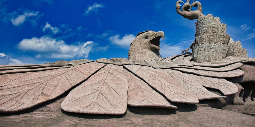 A picture of a massive bird figure made out of rock under a clear blue sky