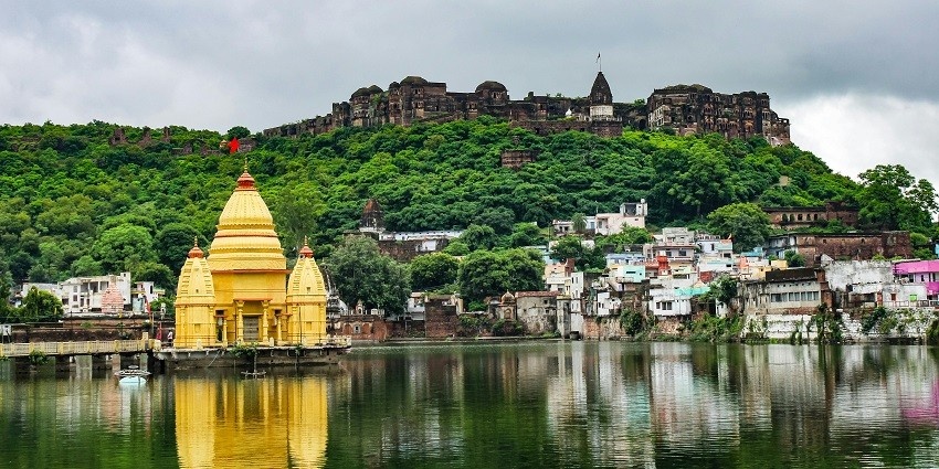 A glimpse of Jayanti Devi Temple surrounded by serene waters and lush green vegetation.