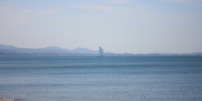 The beautiful image of the crystal clear waters of Jomtien Beach, located in Thailand.