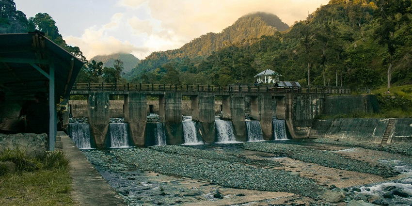 Image of tranquil Dam with Flowing Water and Mountainous Backdrop - oldest national park in India