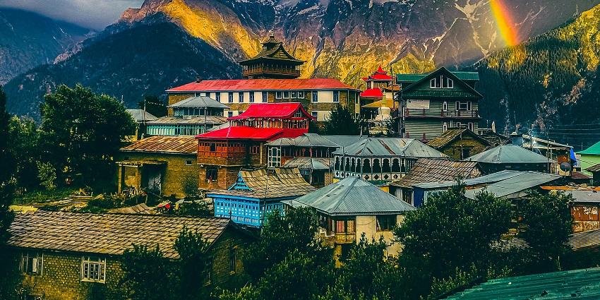 An image of a beautiful rainbow shining in the sky over a mountain village in Kalpa.