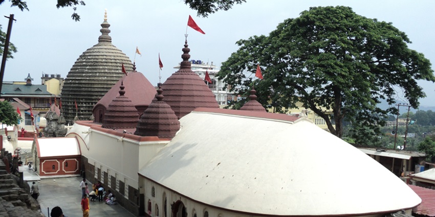 Image of Kamakhya Mandir with its ornate carvings, surrounded by lush greenery.