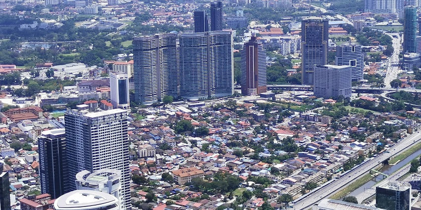 An aerial view of an urban centre of a city with tall skyscrapers amidst a green cityscape