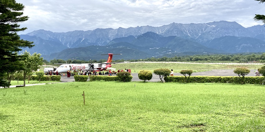 Aerial view of Kangra Airport in Himachal Pradesh, surrounded by lush green mountains.