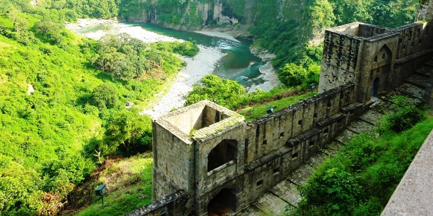 An aerial view of the iconic Kangra Fort surrounded by lush green vegetation in Kangra.