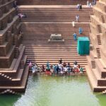 An image of people near the scared pond at Peralassery Temple located in Kerala.