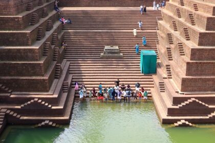 An image of people near the scared pond at Peralassery Temple located in Kerala.