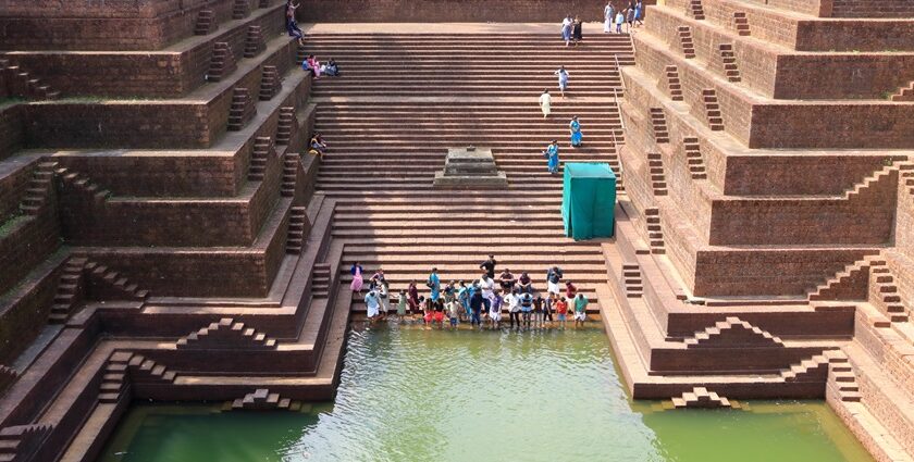 An image of people near the scared pond at Peralassery Temple located in Kerala.