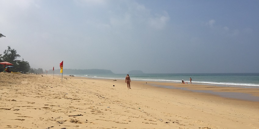 People strolling through the pristine Karon Beach, one of the best beaches in Phuket.