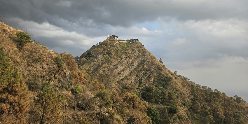 A breathtaking view of Kasauli showcasing majestic peaks dotted with lush greenery.