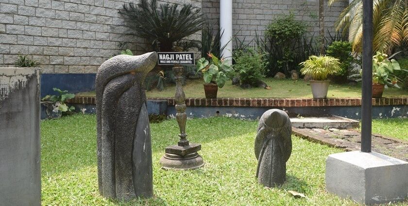 Artefacts placed in a museum's garden with green grass and trees, on a bright, sunny day