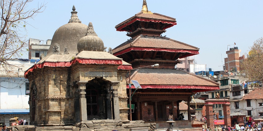 A frontal view of a temple with devotees gathered in front to seek blessings