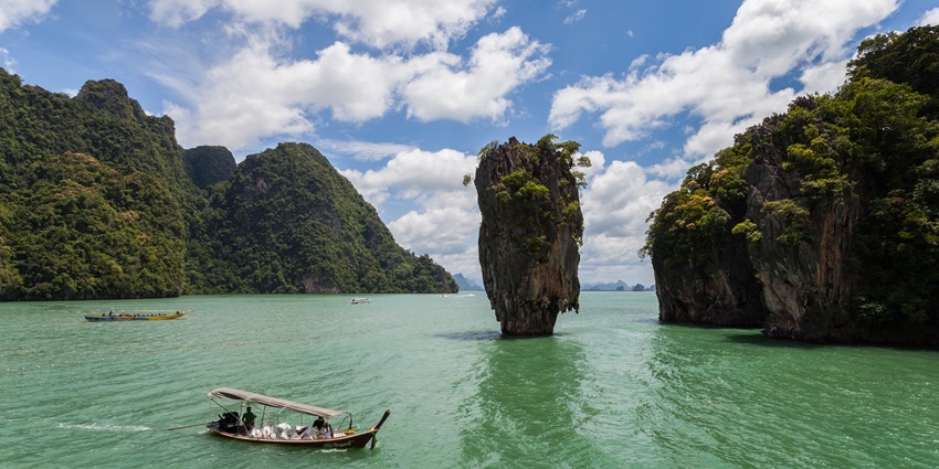 People on a boat in a sea near tall islands