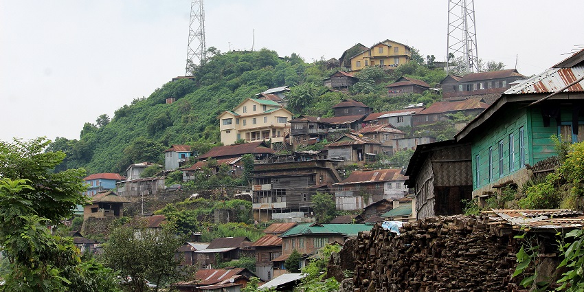 Khonoma Village showcasing traditional Naga homes and a backdrop of rolling hills.