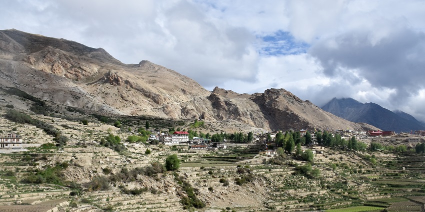A distant view of the Kinnaur town of Himachal Pradesh with tall mountains in the background