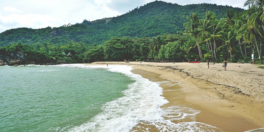 A scenic view of splashing waves hitting the pristine sands at Klong Jark Beach.