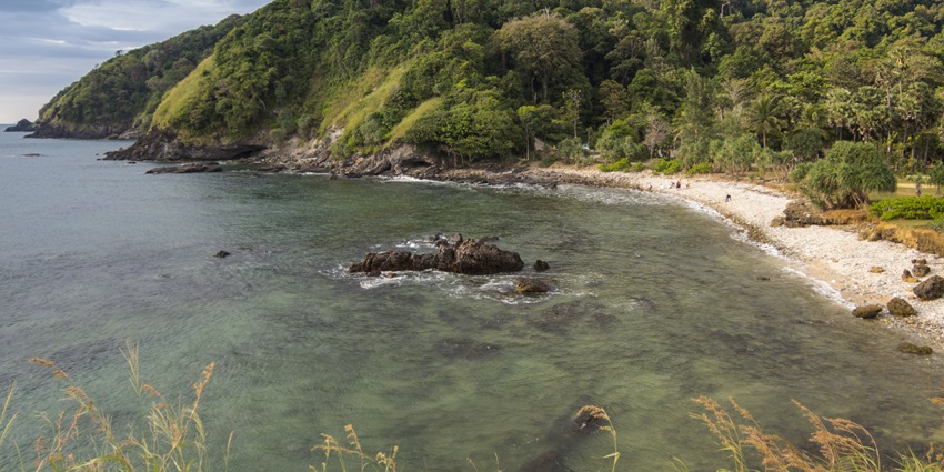 An aerial view of serene waters of Koh Lanta surrounded by sands and lush greenery.