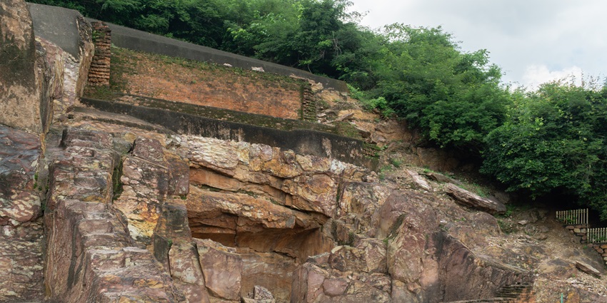 A picture of the entrance of a massive cave system in Kerala, surrounded by greenery