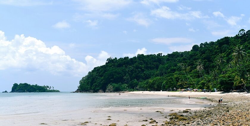 A scenic view of the sandy shores and shimmering waters of Koh Chang Beach, Thailand.