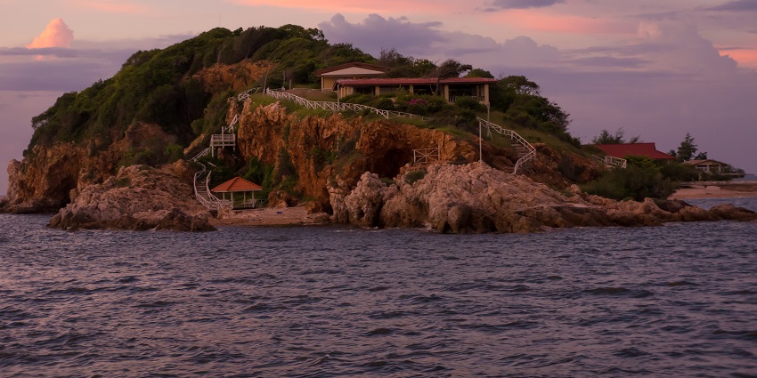 An island during the twilight time with wooden houses built on them, perfect place for scuba diving in Pattaya