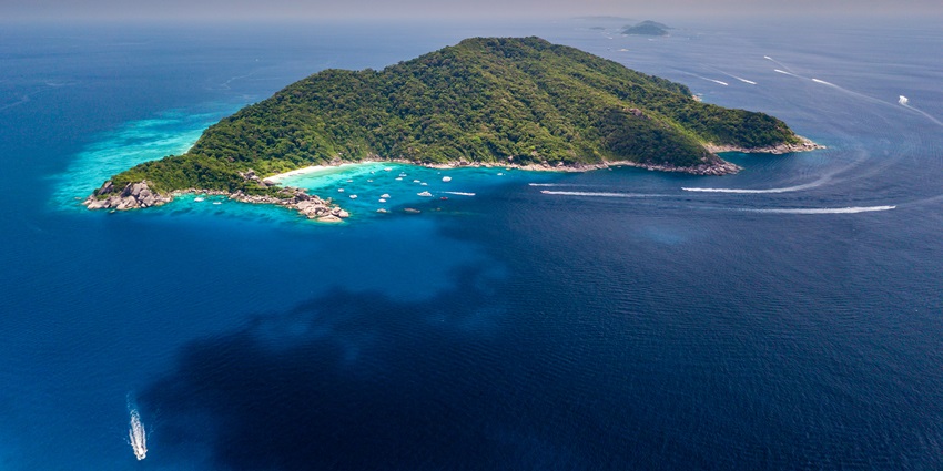 An aerial view of a beach famous for scuba diving in Thailand with people enjoying on the beach